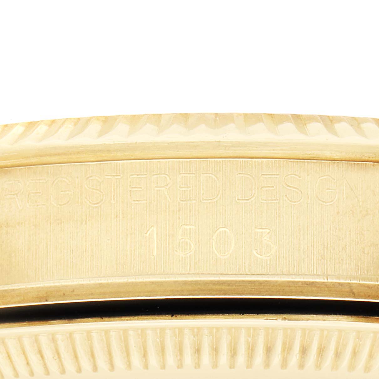 The image shows a close-up of the case side, focusing on the bezel and "Registered Design 1503" engraving of a Rolex Date watch.