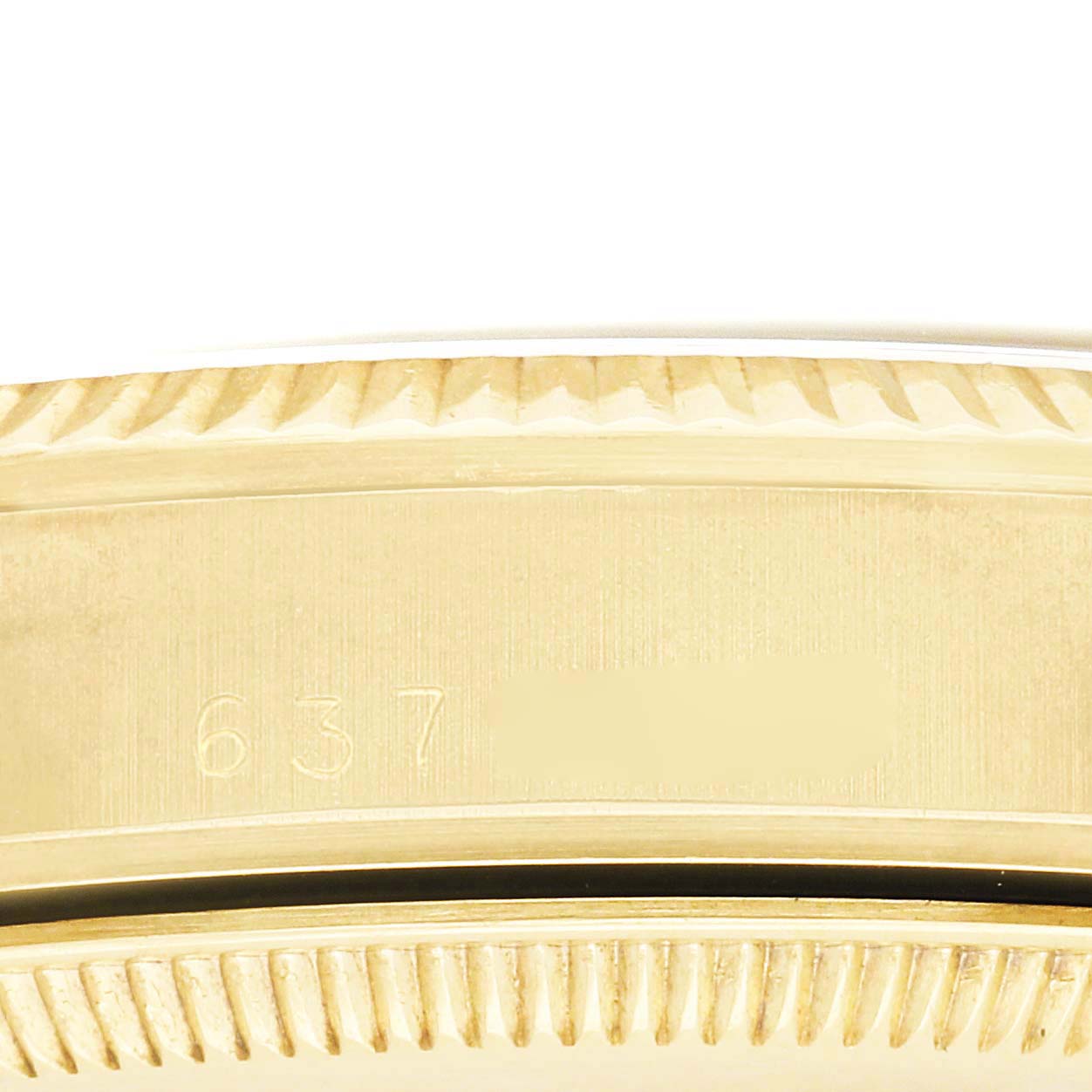 The image shows a close-up of the fluted bezel and part of the case of a Rolex Date model.