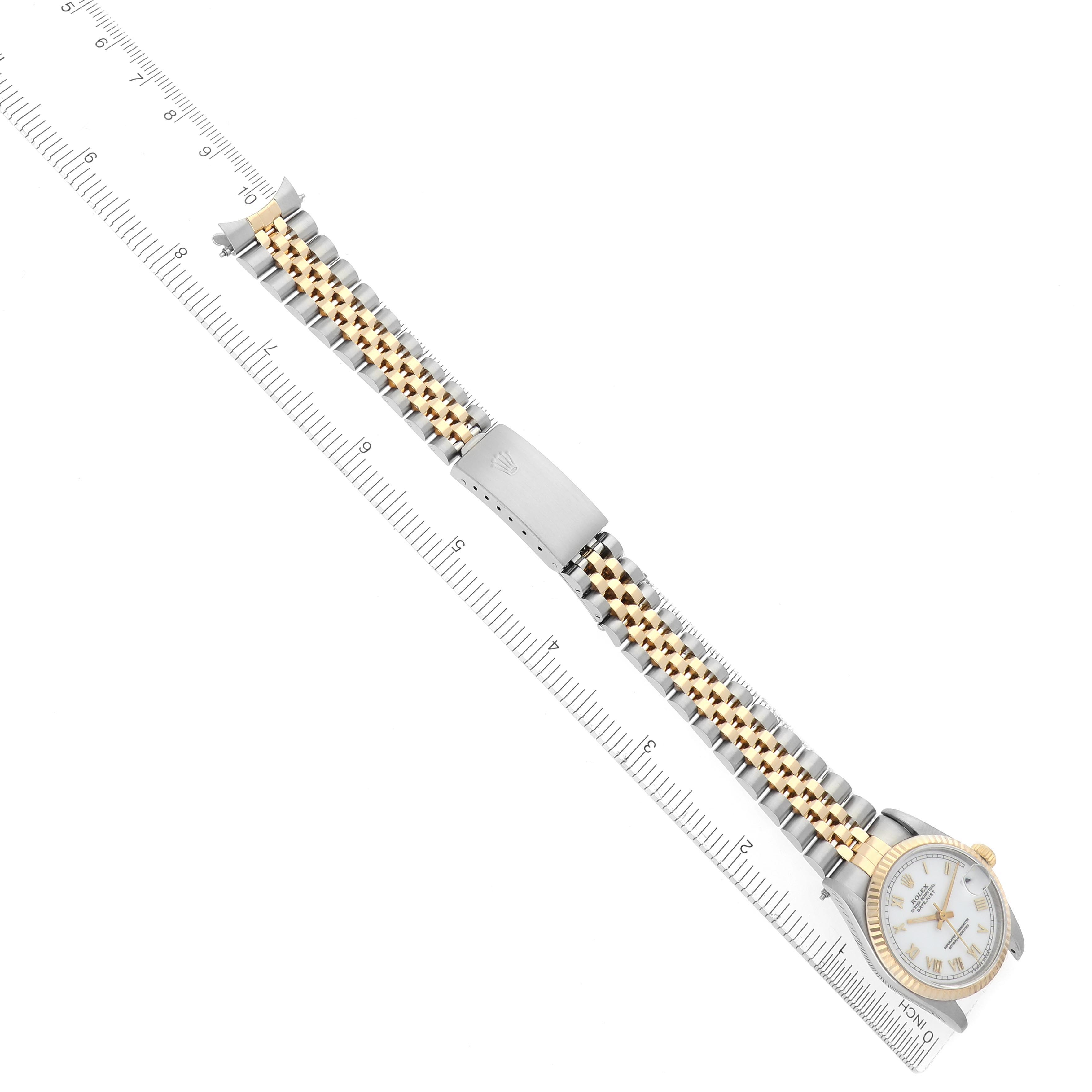 The Rolex Mid-Size 68273 Women's Steel and Gold (two tone) White Dial 68273 Women's Steel and Gold (two tone) White Dial watch is shown from a top-down angle, displaying its two-tone bracelet and clasp alongside a ruler for scale.