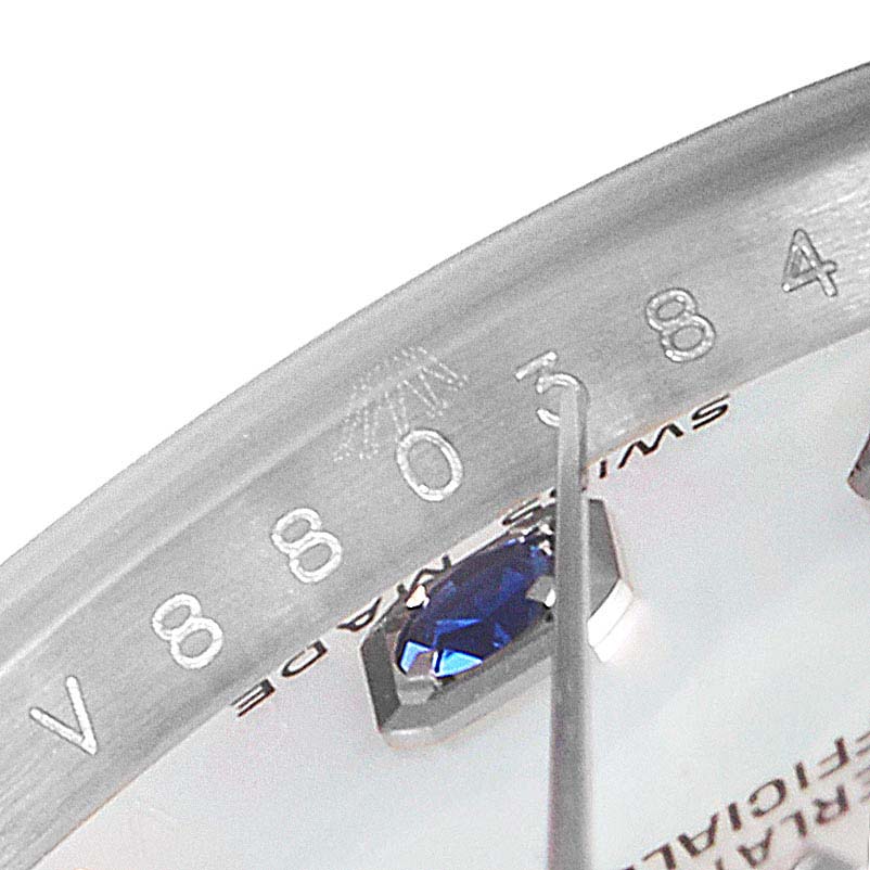 The image shows a close-up of the serial number and a blue gemstone marker on the dial of a Rolex Datejust 179174 Women
s Stainless Steel Mother of Pearl Dial 179174 Women
s Stainless Steel Mother of Pearl Dial watch.