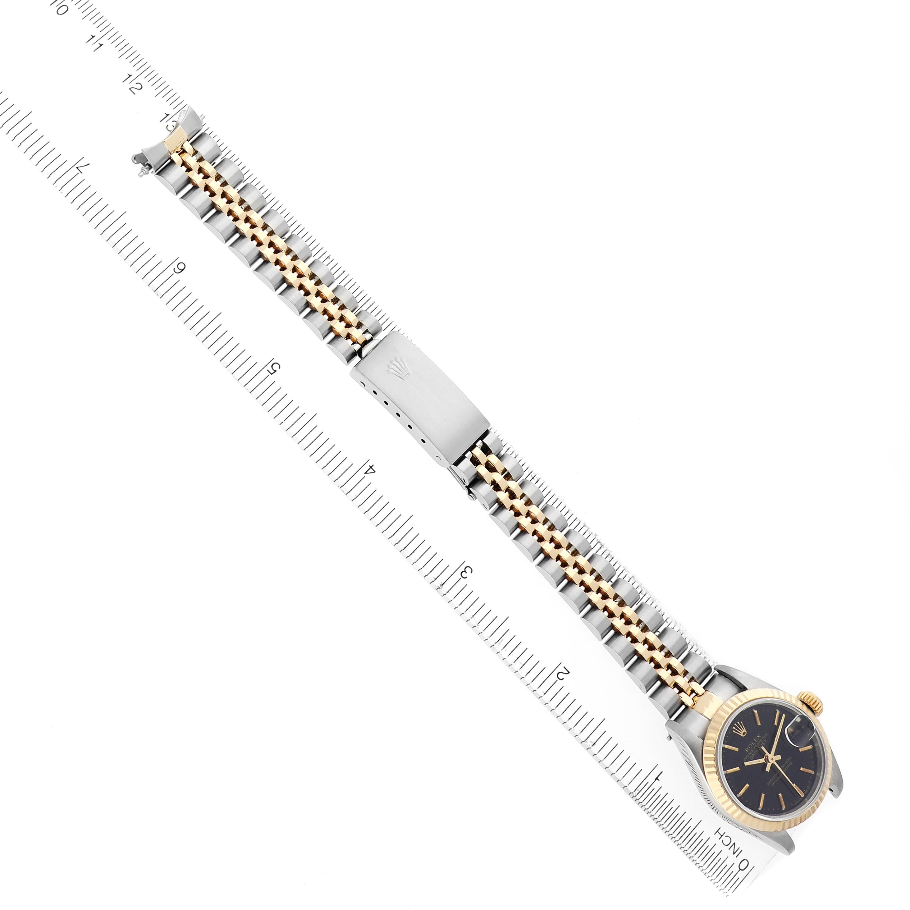 The Rolex Datejust 69173 Women
s Steel and Gold (two tone) Black Dial 69173 Women
s Steel and Gold (two tone) Black Dial watch is shown from a top-down angle, featuring the full bracelet, clasp, and watch face.