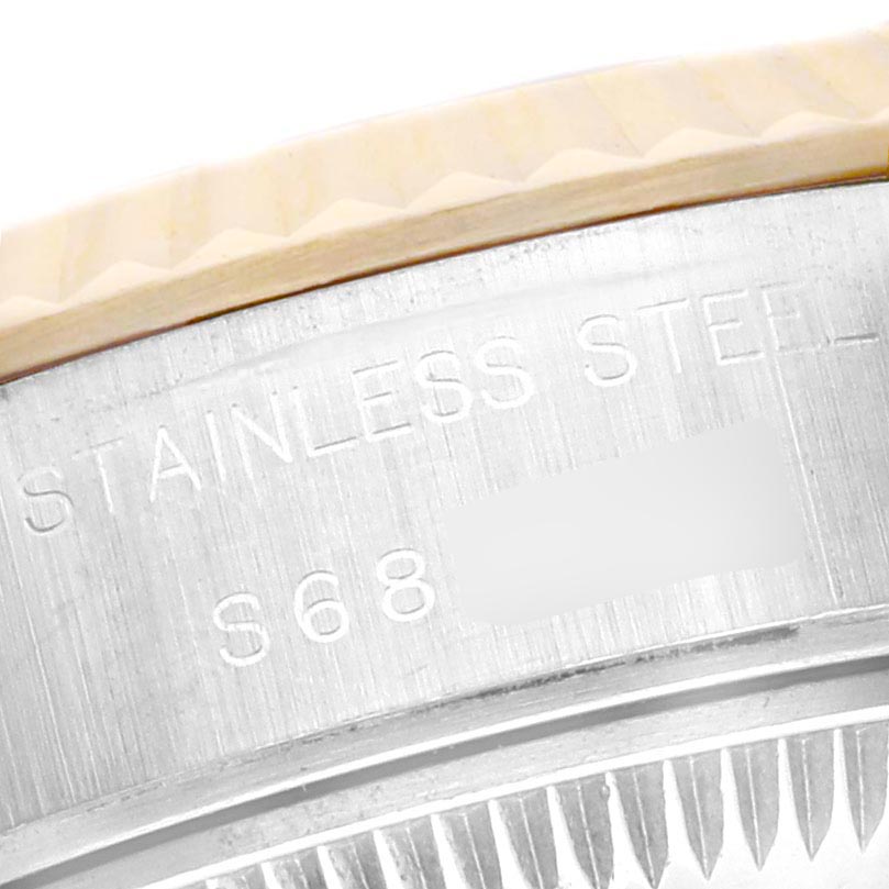 The image shows a close-up of the Rolex Datejust 69173 Women
s Steel and Gold (two tone) Black Dial 69173 Women
s Steel and Gold (two tone) Black Dial
s brushed stainless steel case and part of the fluted bezel.