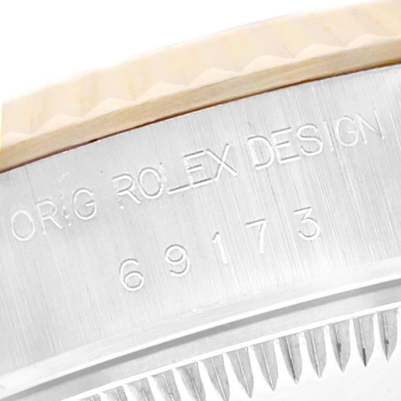 The image shows a close-up of the side of a Rolex Datejust 69173 Women
s Steel and Gold (two tone) Black Dial 69173 Women
s Steel and Gold (two tone) Black Dial, highlighting the engraved serial number and "ORIG ROLEX DESIGN."
