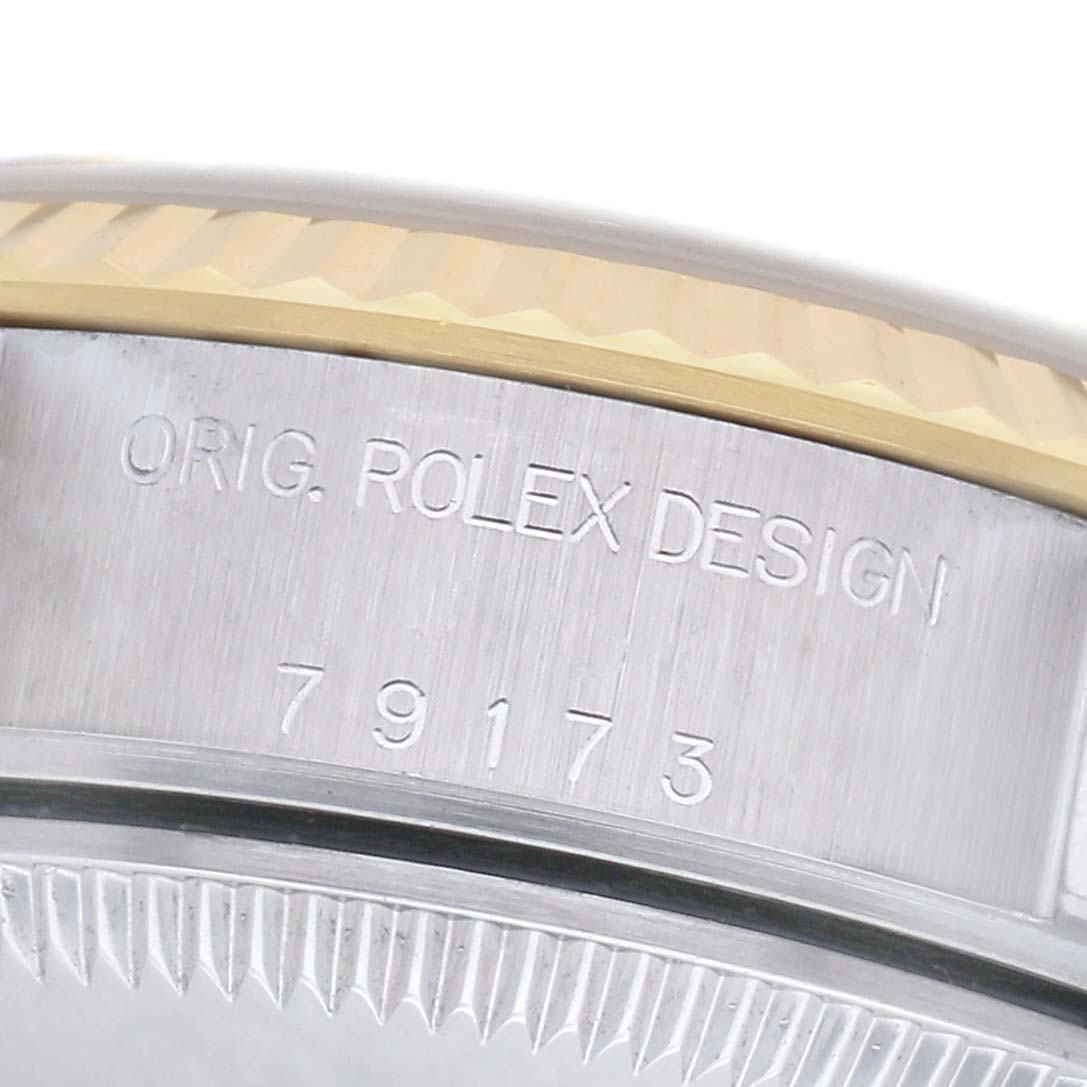 The image shows a close-up of the Rolex Datejust 79173 Women's Steel and Gold (two tone) Champagne Dial 79173 Women's Steel and Gold (two tone) Champagne Dial's bezel and case, with engraved model details.