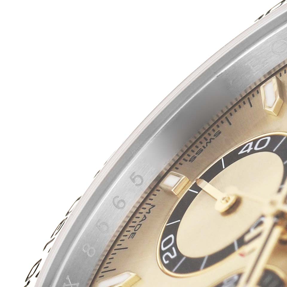 The image shows a close-up of the bezel, part of the dial, and sub-dials of the Rolex Daytona 126503 Men's Steel and Gold (two tone) Champagne Dial watch at an angle.