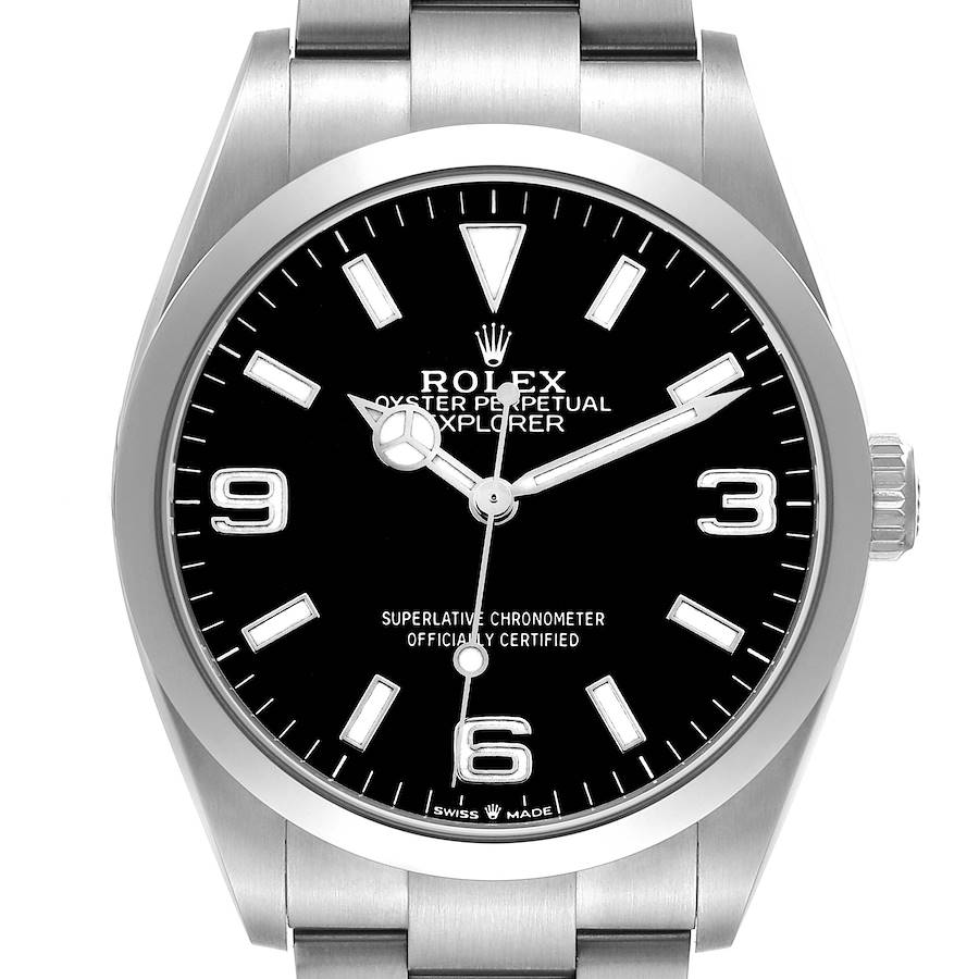 The Rolex Explorer watch is shown from the front, displaying its black dial, luminous markers, hands, and stainless steel case.