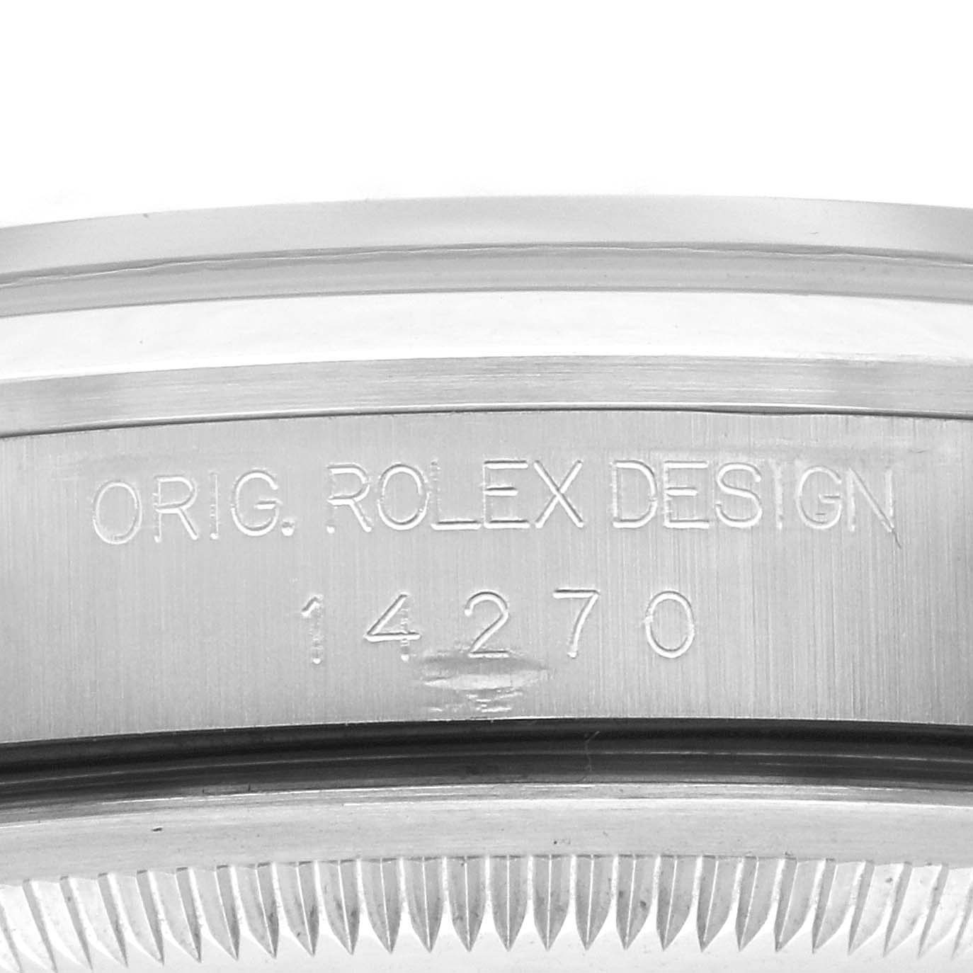 The image shows the case side of a Rolex Explorer 14270 Men
s Stainless Steel Black Dial 14270 Men
s Stainless Steel Black Dial, focusing on the engraved model number "14270" and the text "ORIG. ROLEX DESIGN."