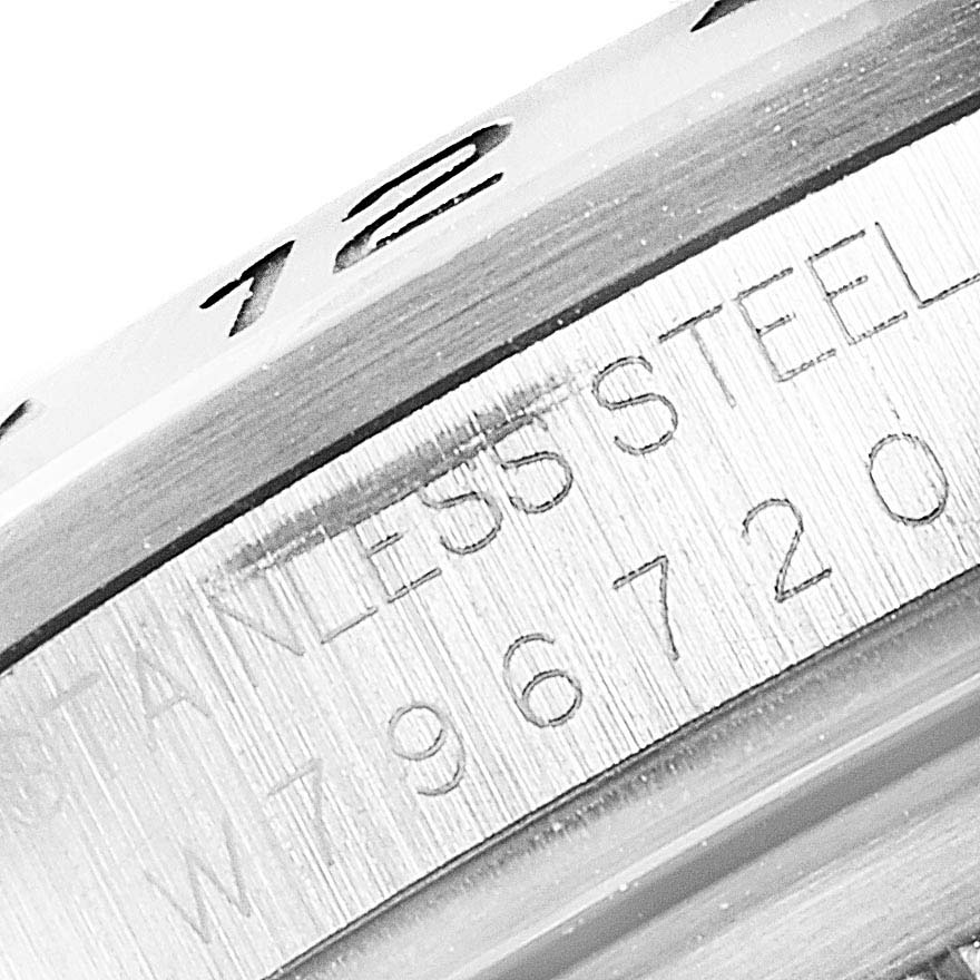 This close-up image of a Rolex Explorer 16570 Men
s Stainless Steel Black Dial 16570 Men
s Stainless Steel Black Dial watch shows the bezel and engraved serial number.