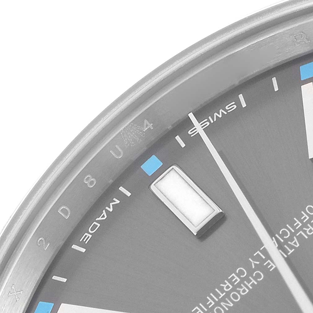 The image shows a close-up of the dial and bezel edge of a Rolex Oyster Perpetual 114300 Men
s Stainless Steel Grey Dial 114300 Men
s Stainless Steel Grey Dial watch, highlighting the hour markers and text details.