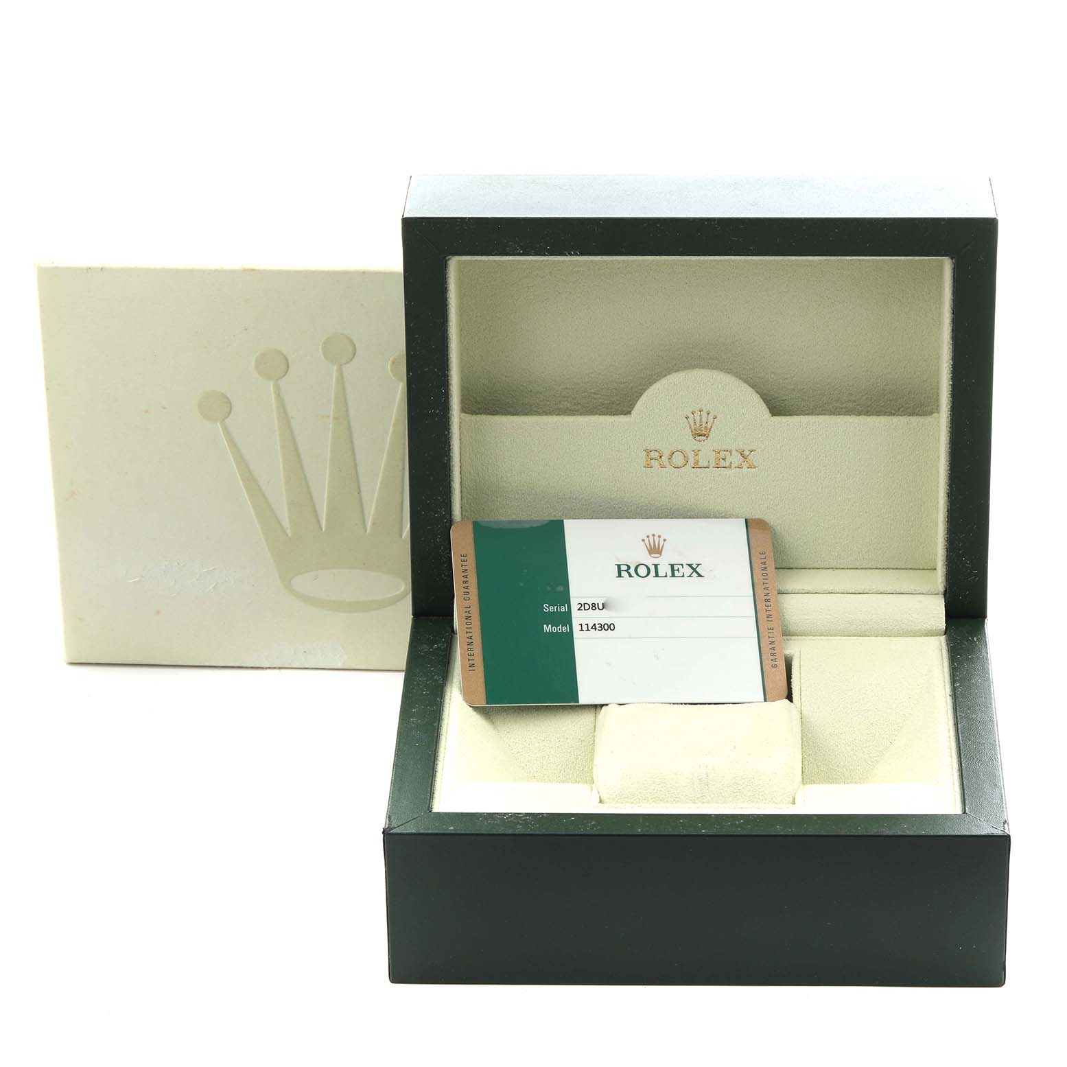 The image shows a Rolex Oyster Perpetual 114300 Men
s Stainless Steel Grey Dial 114300 Men
s Stainless Steel Grey Dial box open with an empty cushion and a warranty card displaying model 114300.
