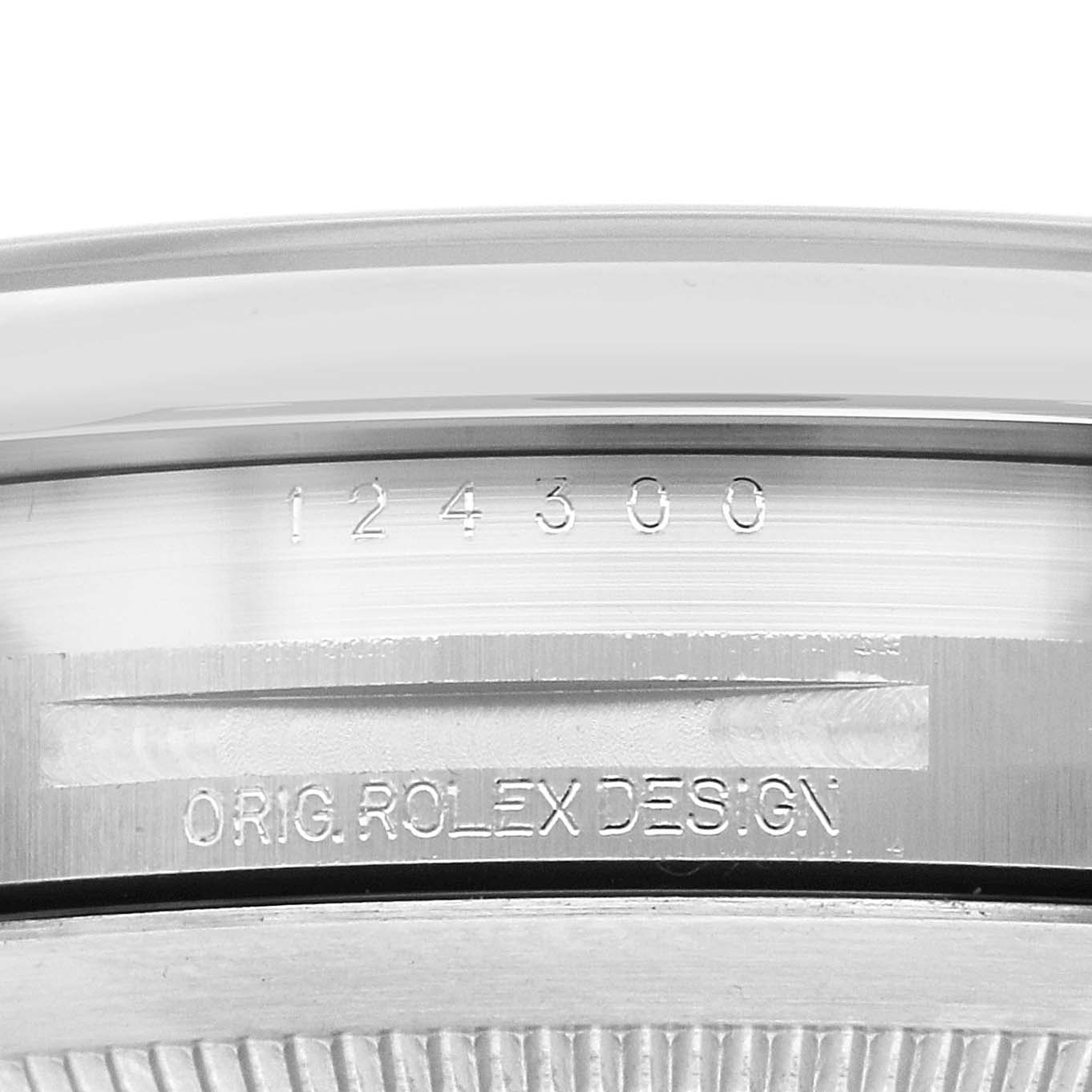 The image shows a close-up of the side of an Oyster Perpetual Rolex, highlighting the engraved model number and "ORIG ROLEX DESIGN."