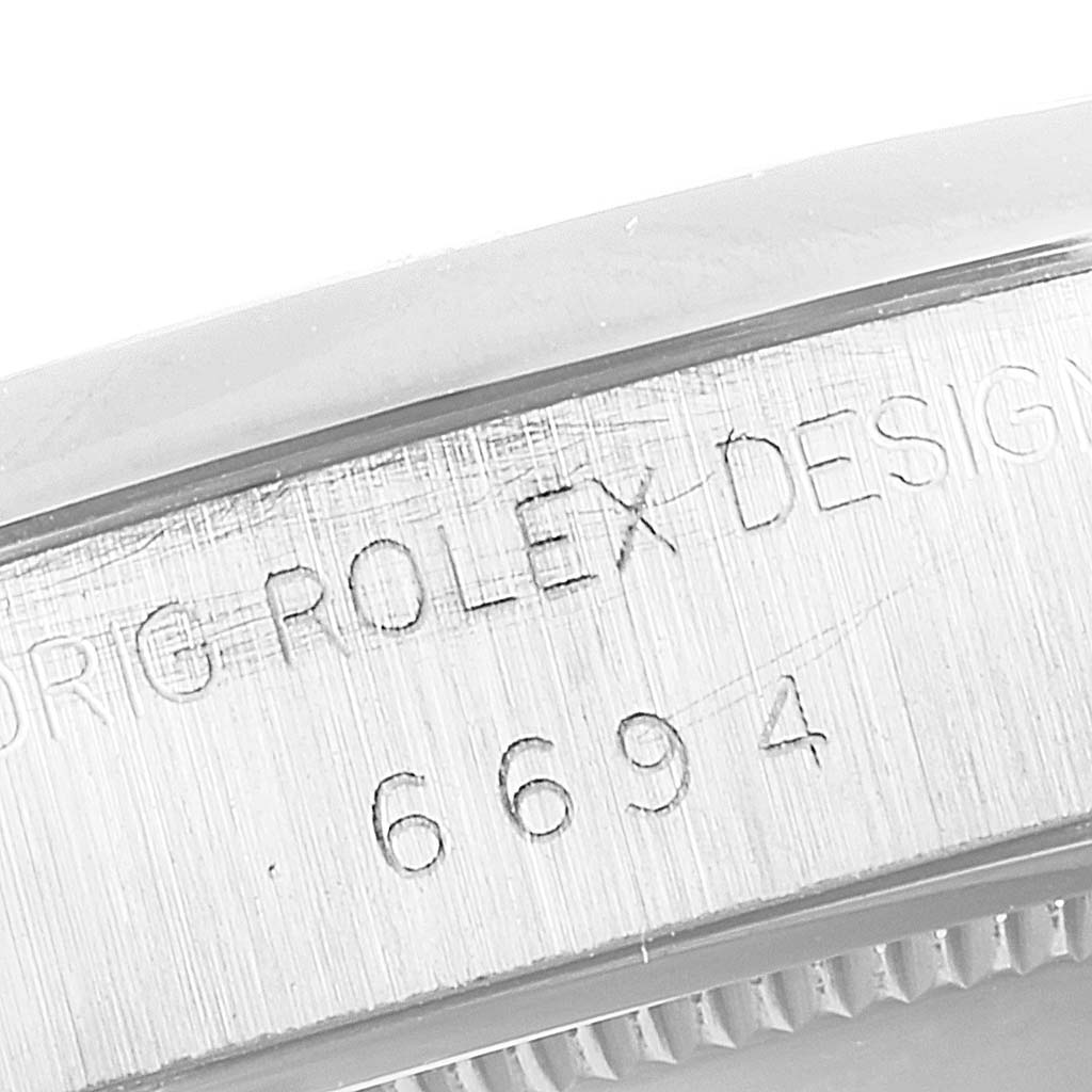 The image shows a close-up of the side engraving on the Rolex Vintage Collection 6694 Men
s Stainless Steel Silver Dial 6694 Men
s Stainless Steel Silver Dial model, displaying "ROLEX DESIGN" and the model number "6694".