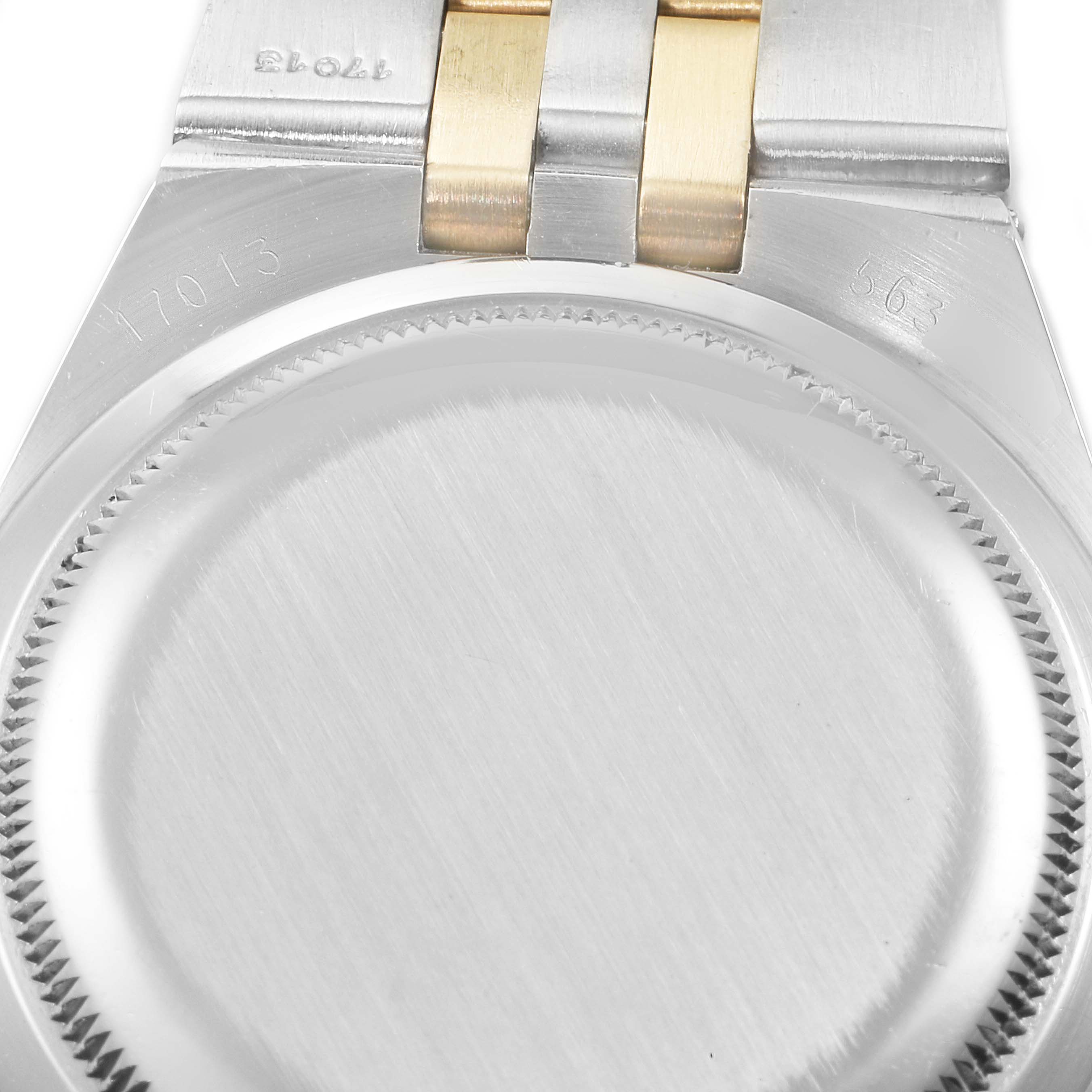 The image shows the back case of an Oysterquartz Rolex watch, with part of the bracelet visible.