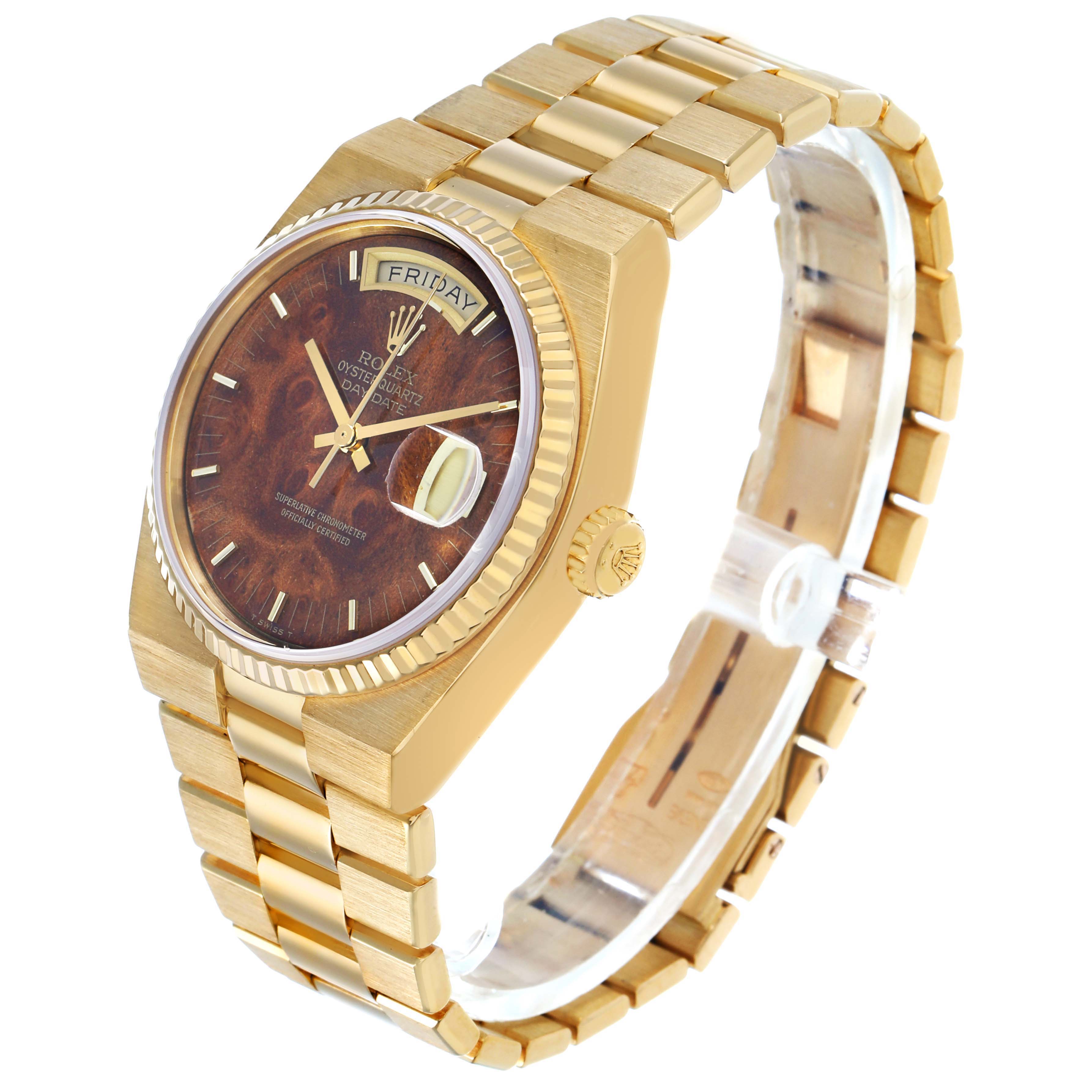 The Rolex Oysterquartz 19018 Men's Yellow Gold Brown Dial watch is shown at an angled side view featuring its case, dial, bracelet, and crown.