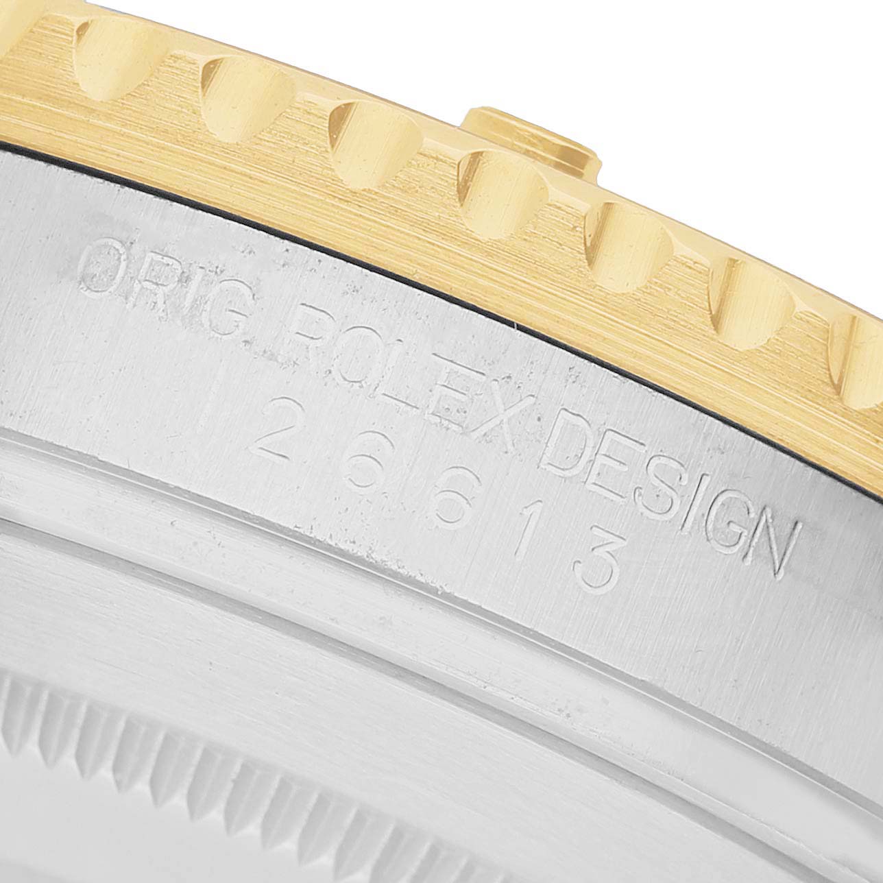 The image shows a close-up of the side of a Rolex Submariner 126613 Men's Steel and Gold (two tone) Blue Dial, highlighting the engraved design number and part of the bezel.