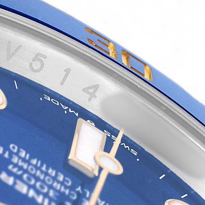 The image shows a close-up of the dial, bezel, and indices of a Rolex Submariner 126613 Men's Steel and Gold (two tone) Blue Dial, focusing on the edge and some markings.