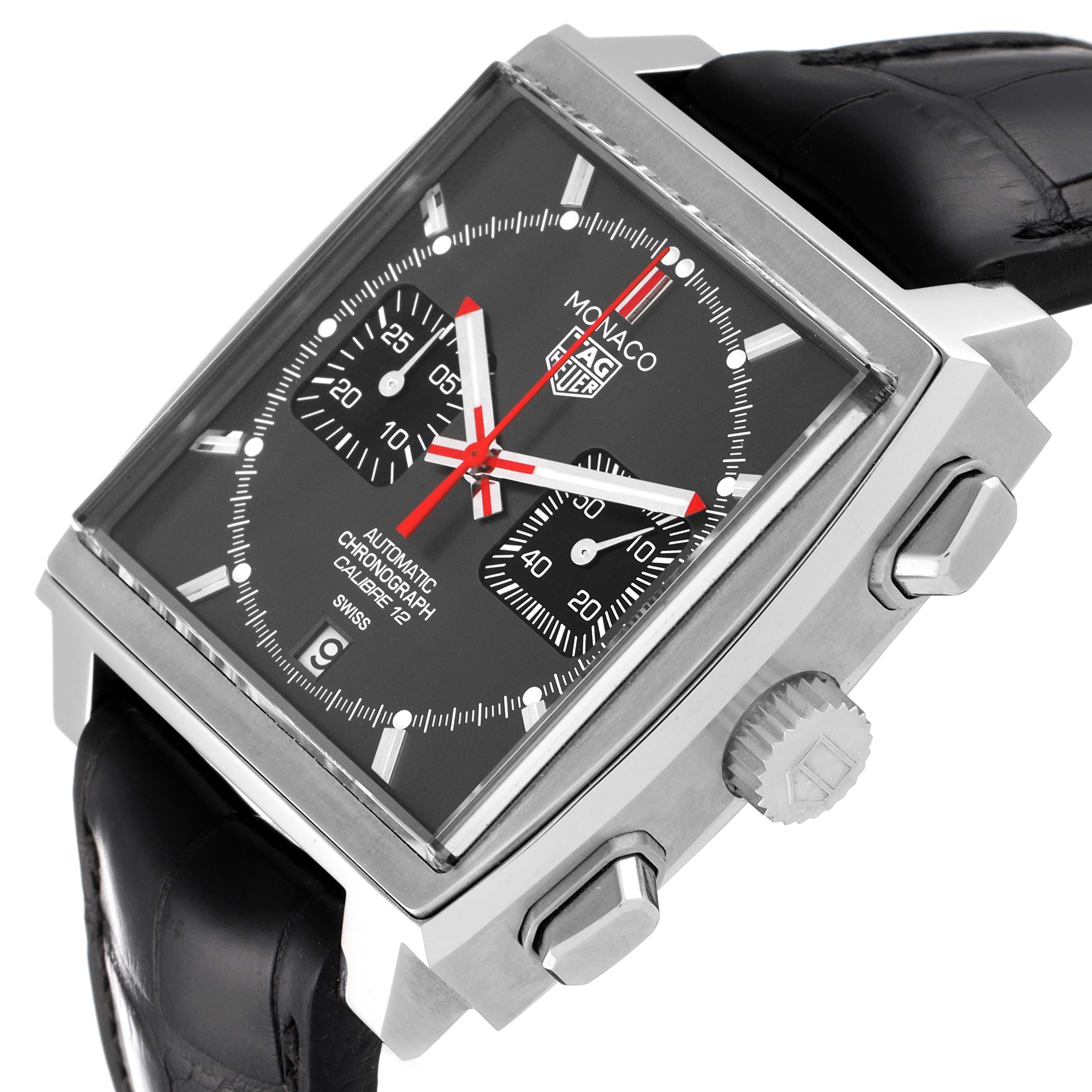 The image shows a Tag Heuer Monaco watch at an angled view, highlighting its black dial, chronograph subdials, case, and crown.