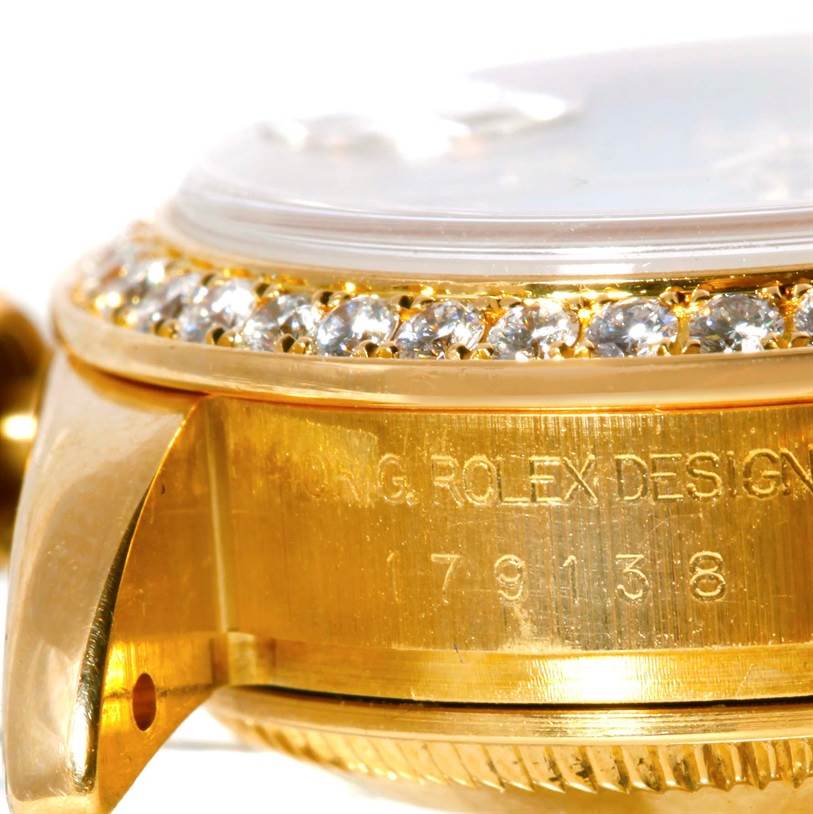This close-up image of the Rolex President 179138 Women's Yellow Gold Mother of Pearl Dial 179138 Women's Yellow Gold Mother of Pearl Dial watch shows the side case engraving and diamond bezel at an angle.