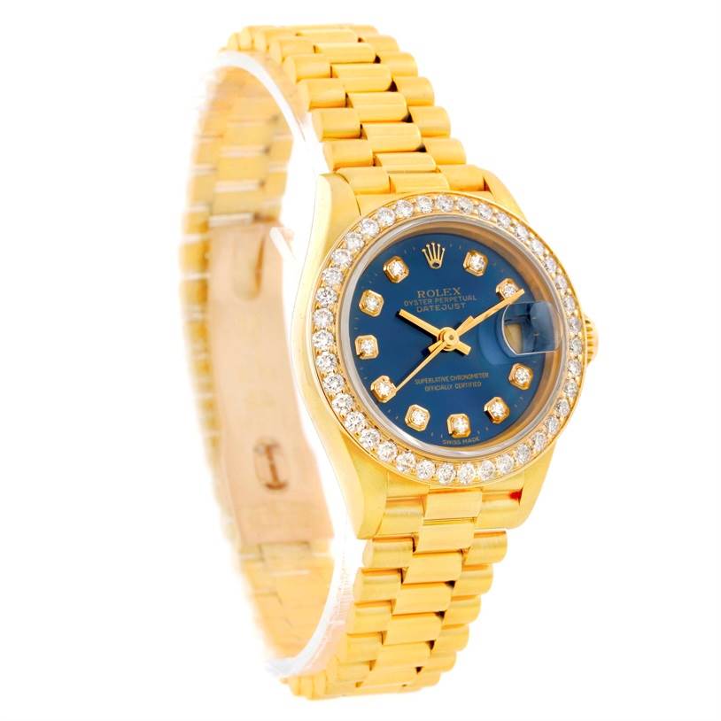 The Rolex President 69178 Women's Yellow Gold Blue Dial 69178 Women's Yellow Gold Blue Dial model is shown at a slight angle, displaying its bracelet, diamond bezel, blue dial, and cyclops lens.