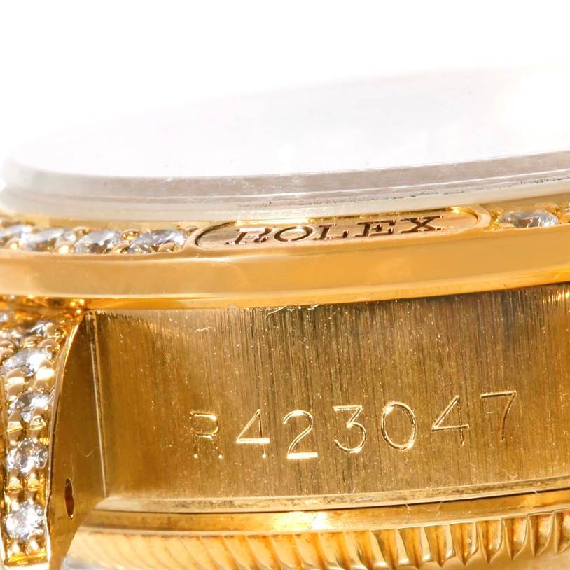 This close-up angle of the Rolex President 69158 Women's Yellow Gold Champagne Dial 69158 Women's Yellow Gold Champagne Dial watch shows part of the bezel, case, and serial number.