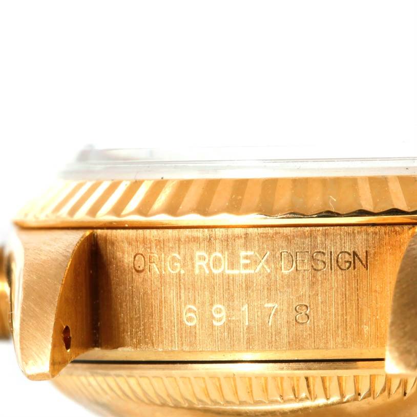 This image shows a close-up of the side case and fluted bezel of the Rolex President 69178 Women's Yellow Gold Black Dial 69178 Women's Yellow Gold Black Dial model, showcasing the design engraving.