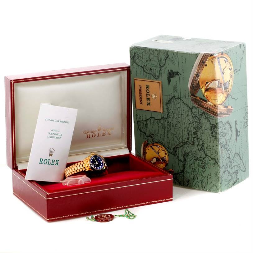 The image shows a Rolex President 69178 Women's Yellow Gold Black Dial 69178 Women's Yellow Gold Black Dial model watch in an open box, accompanied by its official chronometer certification and warranty.