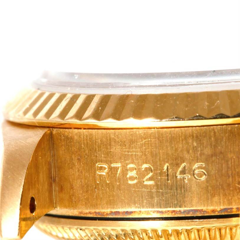 This close-up image of the Rolex President 69178 Women's Yellow Gold Brown Dial 69178 Women's Yellow Gold Brown Dial watch shows its side with the serial number and part of the bezel.