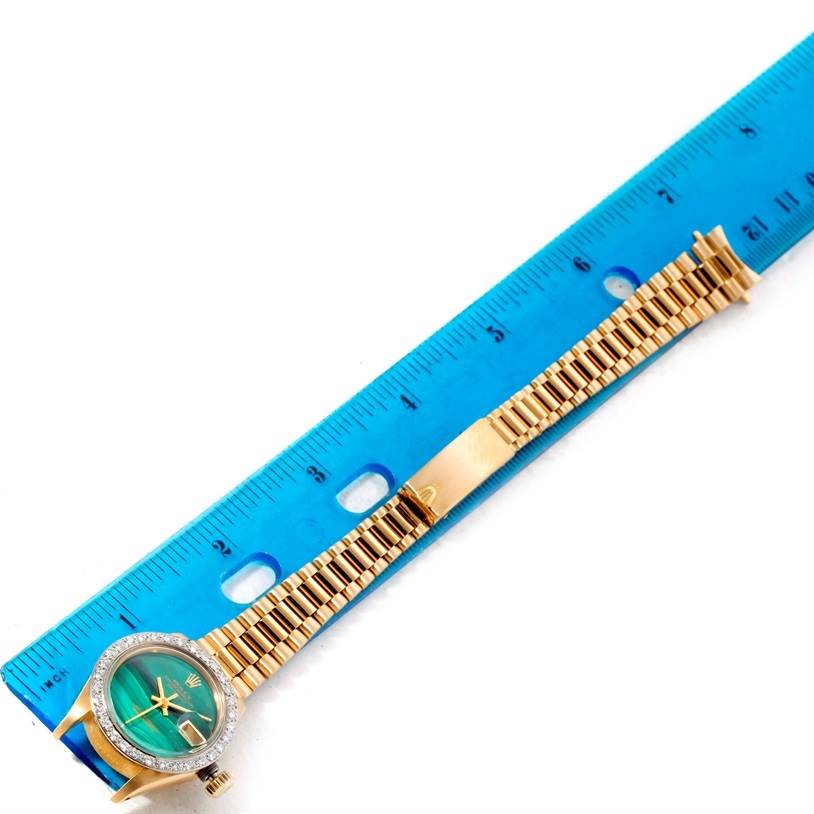 The image shows a Rolex President 6917 Women's Yellow Gold Green Dial 6917 Women's Yellow Gold Green Dial watch laid flat, alongside a blue ruler, displaying the face, bezel, and bracelet.