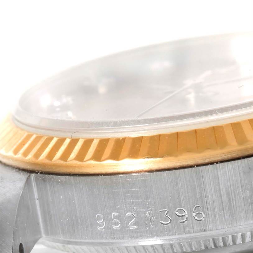 This close-up image shows the side of a Rolex President 68279 Women's White Gold Brown Dial 68279 Women's White Gold Brown Dial watch, highlighting its bezel, crystal, and part of the case with engraved serial numbers.