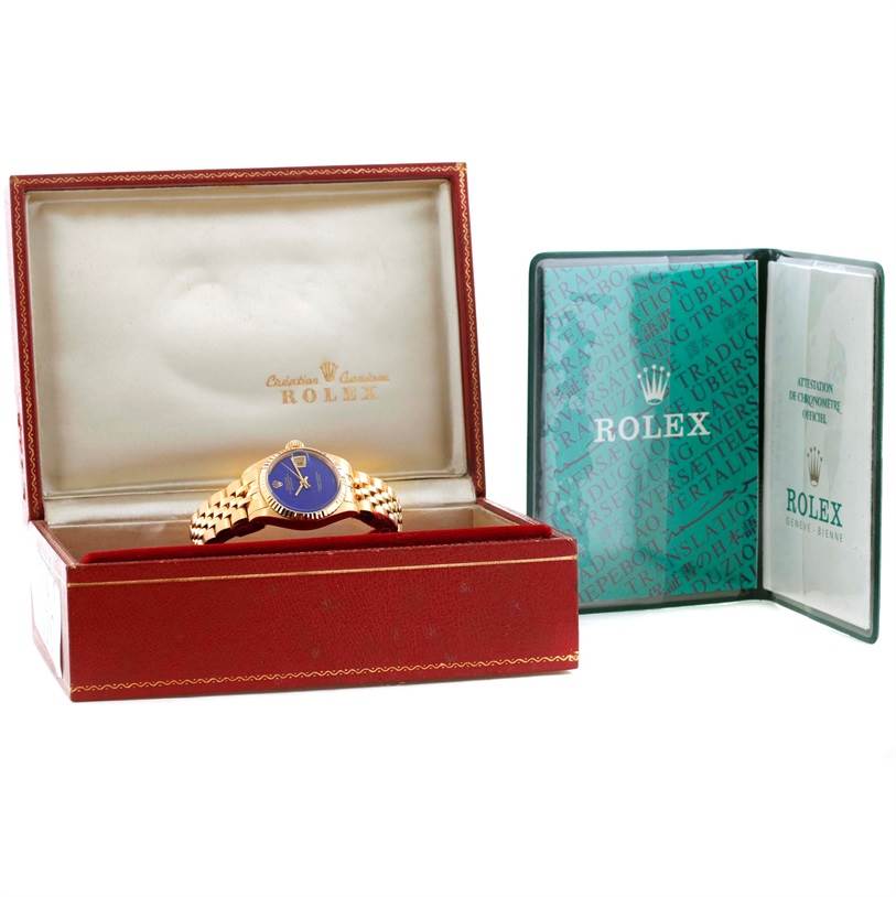The Rolex President 6917 Women's Yellow Gold Blue Dial 6917 Women's Yellow Gold Blue Dial model watch is shown in its open box, with accompanying booklets and a visible bracelet.