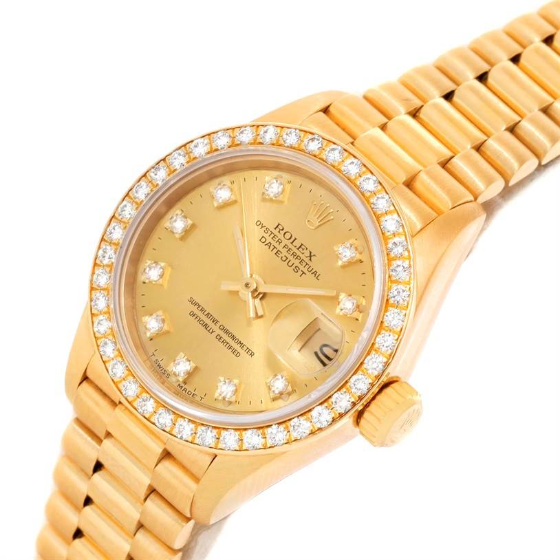 The image shows a close-up angle of a Rolex President 69138 Women's Yellow Gold Champagne Dial 69138 Women's Yellow Gold Champagne Dial watch, highlighting its gold diamond bezel, dial, and part of the bracelet.
