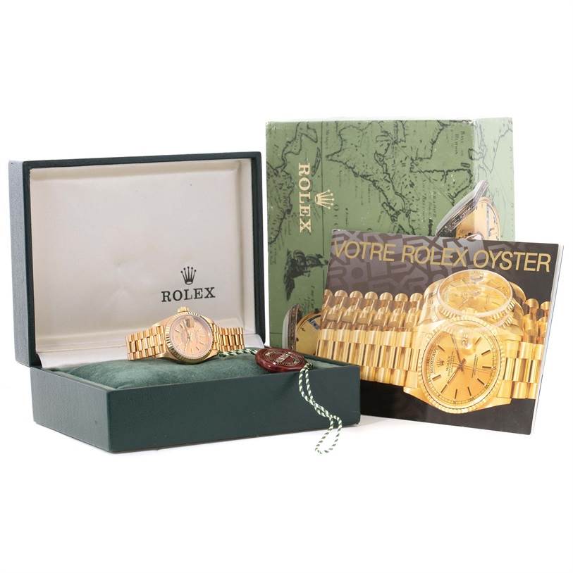 The image shows a Rolex President 69178 Women's Yellow Gold Champagne Dial 69178 Women's Yellow Gold Champagne Dial model watch in its original box along with a manual and packaging.