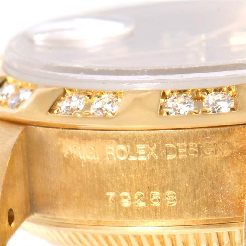 This close-up image shows a partial view of the bezel and case of a Rolex President 79258 Women's Yellow Gold Champagne Dial 79258 Women's Yellow Gold Champagne Dial watch, highlighting its diamonds and engraved model number.