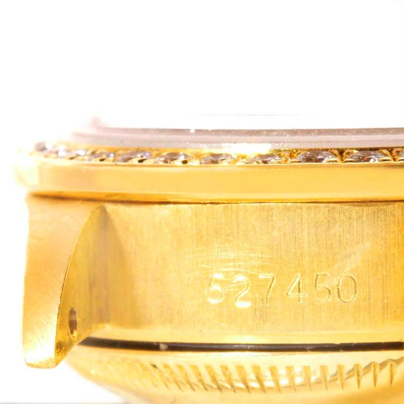 This image shows a close-up of the side of a Rolex President 69138 Women
s Yellow Gold Pink Dial 69138 Women
s Yellow Gold Pink Dial watch case, highlighting the bezel and part of the serial number.