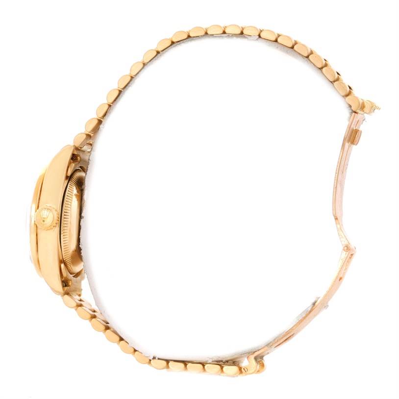 This image shows a Rolex President 69138 Women
s Yellow Gold Pink Dial 69138 Women
s Yellow Gold Pink Dial model watch from a side angle, highlighting the case, crown, and bracelet.