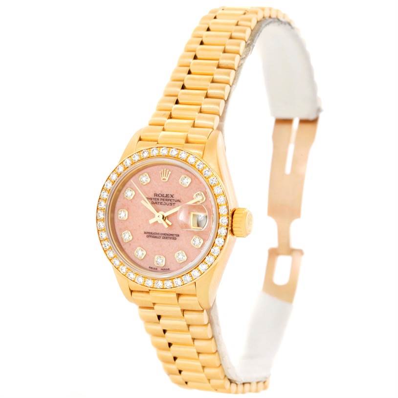 The Rolex President 69138 Women
s Yellow Gold Pink Dial 69138 Women
s Yellow Gold Pink Dial model watch is shown at a tilted angle, highlighting its gold bracelet and diamond-encrusted pink dial.