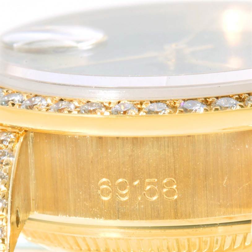 Close-up of the Rolex President 69158 Women's Yellow Gold Black Dial 69158 Women's Yellow Gold Black Dial model watch showing the bezel with diamonds and the side case with model number 69158.