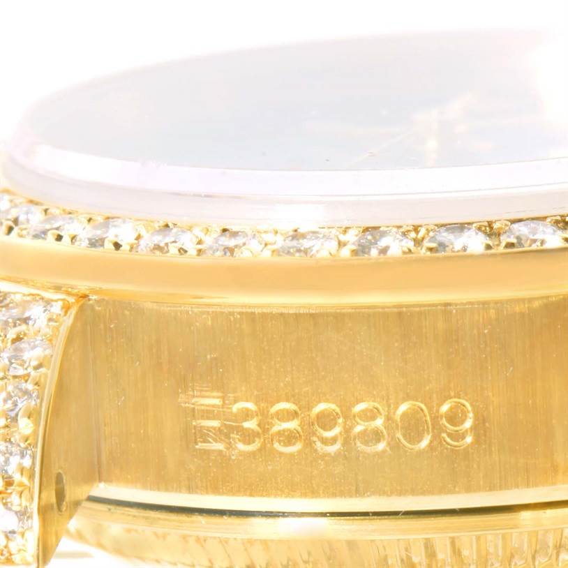 The image shows a close-up of the side of a Rolex President 69158 Women's Yellow Gold Black Dial 69158 Women's Yellow Gold Black Dial watch, highlighting its serial number and diamond-encrusted details.