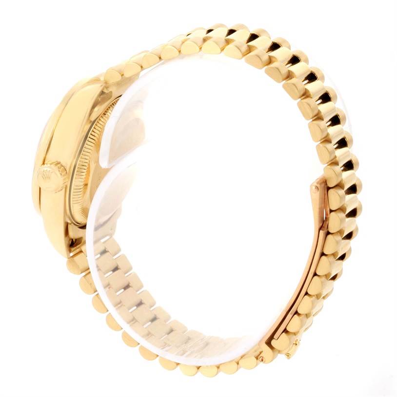 The image shows a side view of a Rolex President 69138 Women's Yellow Gold Champagne Dial 69138 Women's Yellow Gold Champagne Dial model watch, focusing on the crown, case, and gold link bracelet.