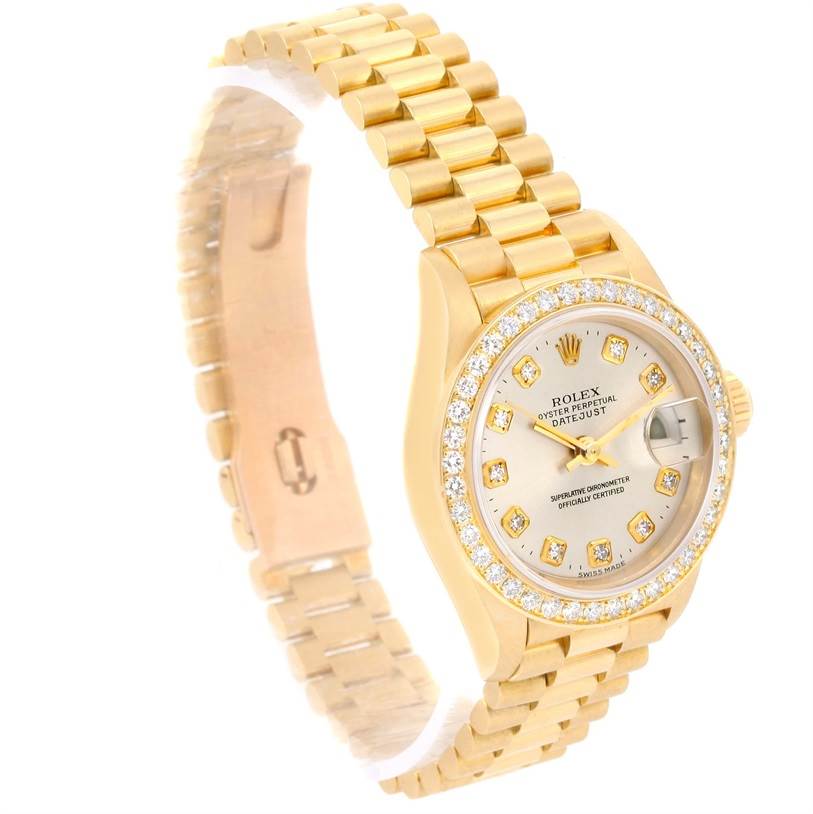The Rolex President 79138 Women's Yellow Gold Silver Dial 79138 Women's Yellow Gold Silver Dial watch is shown at a slight angle highlighting its golden bracelet, diamond-set bezel, and dial.