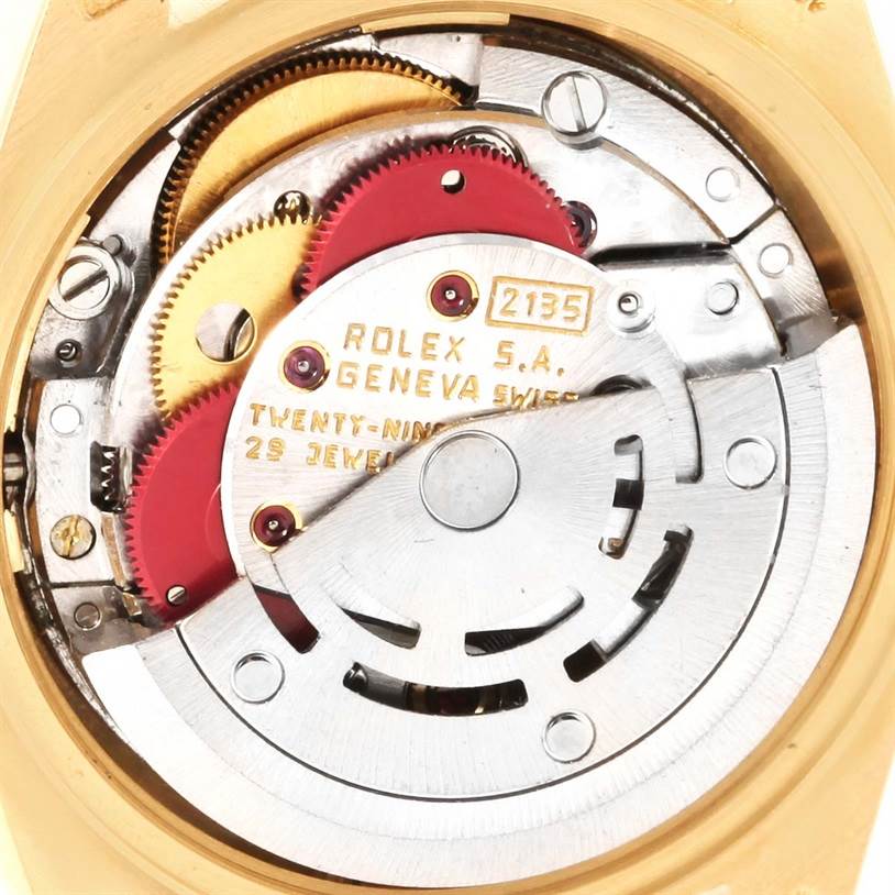 The image shows the inner mechanical movement parts of a Rolex President 69278 Women's Yellow Gold Brown Dial 69278 Women's Yellow Gold Brown Dial watch, highlighting the gears and rotor.