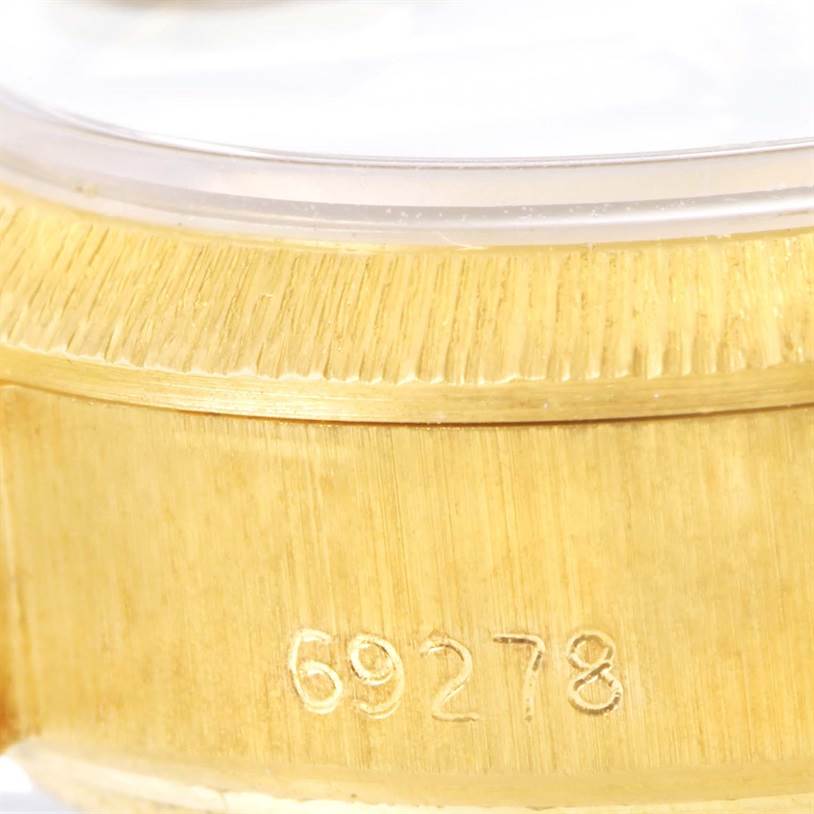 The image shows a close-up of the gold case side of a Rolex President 69278 Women's Yellow Gold Brown Dial 69278 Women's Yellow Gold Brown Dial model watch with the reference number 69278 engraved.