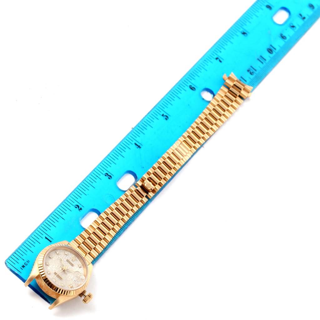 The Rolex President 69178 Women's Yellow Gold Beige Dial 69178 Women's Yellow Gold Beige Dial model watch is shown from a top-down angle, with the entire watch band and face aligned alongside a blue ruler.