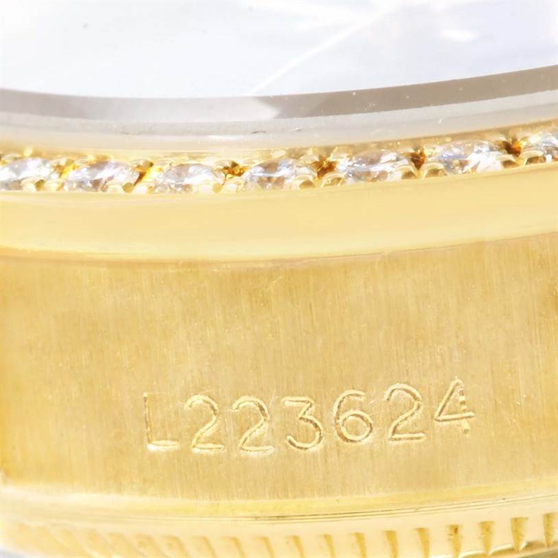 The image shows a close-up angle of the gold bezel with diamond accents and the engraved serial number on a Rolex President 69178 Women's Yellow Gold Black Dial 69178 Women's Yellow Gold Black Dial model watch.