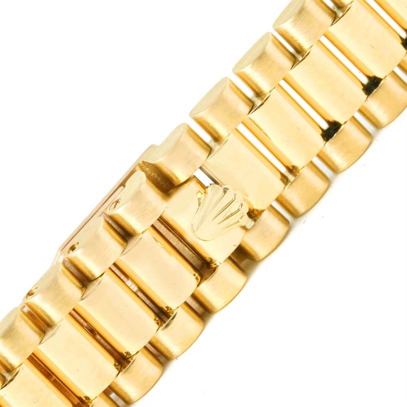 The image shows a close-up of the gold bracelet with the signature Rolex clasp of the President model by Rolex.