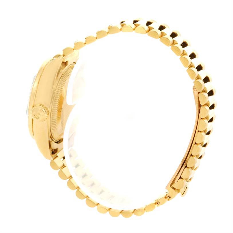 This side-angle view of the Rolex President 69158 Women's Yellow Gold Silver Dial 69158 Women's Yellow Gold Silver Dial model watch shows the case, crown, and bracelet of the timepiece.