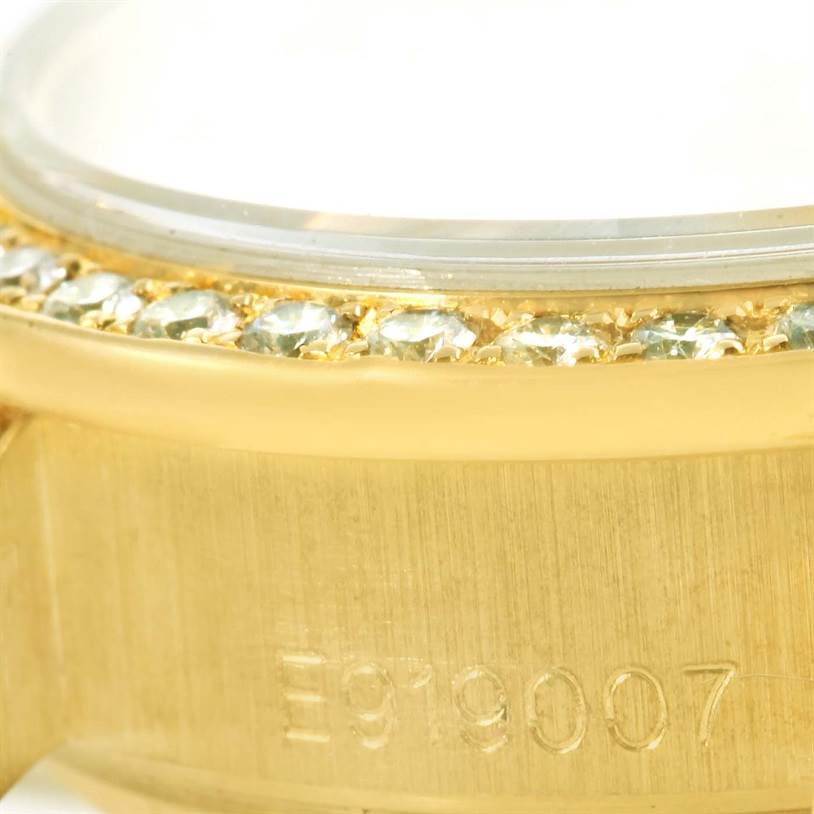 The image shows a close-up of the side profile of a Rolex President 69158 Women's Yellow Gold Silver Dial 69158 Women's Yellow Gold Silver Dial watch, highlighting the diamond-encrusted bezel and part of the serial number.