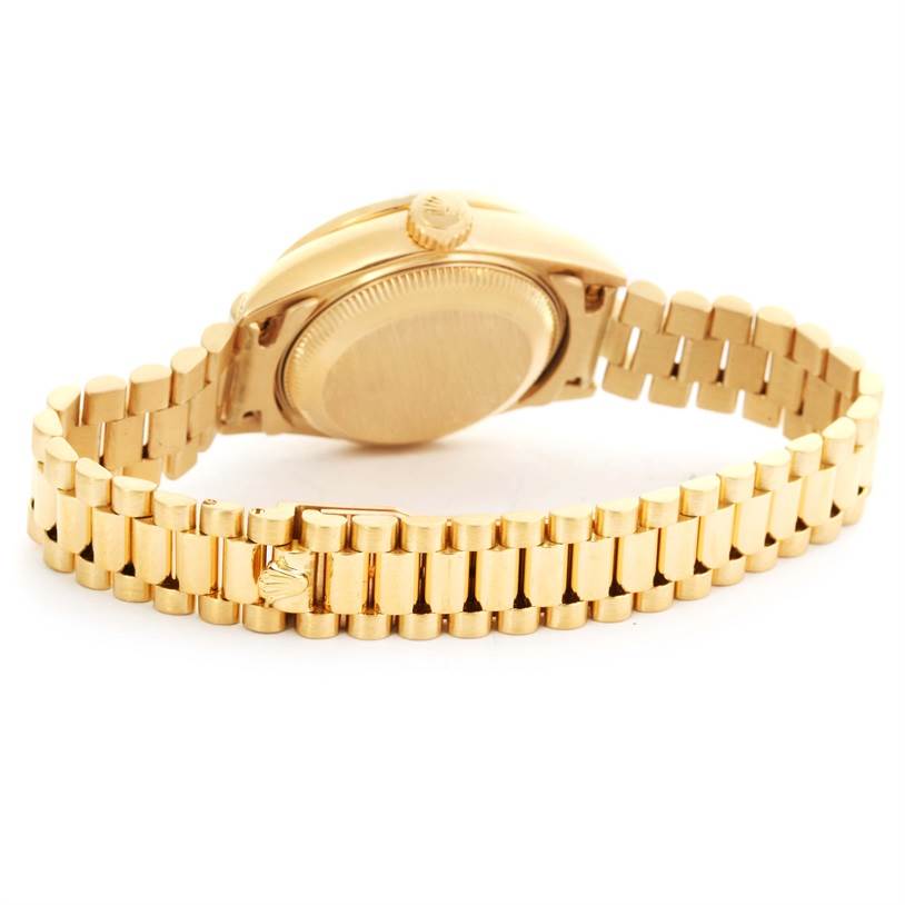 The image shows the back view of a Rolex President 69158 Women's Yellow Gold Silver Dial 69158 Women's Yellow Gold Silver Dial model watch, highlighting its case back and gold bracelet with the clasp open.