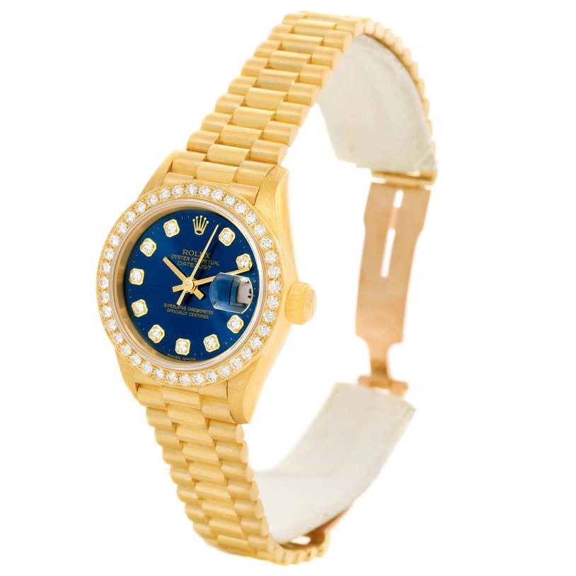 This image shows a Rolex President 69138 Women's Yellow Gold Blue Dial 69138 Women's Yellow Gold Blue Dial model watch with a gold finish, blue face, diamond bezel, and partially open band at a slight angle.