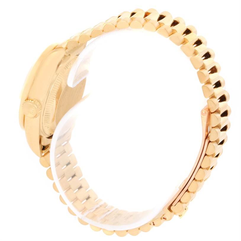 The image shows a side angle of the Rolex President 69178 Women's Yellow Gold Black Dial 69178 Women's Yellow Gold Black Dial model watch with a focus on its gold bracelet and casing.